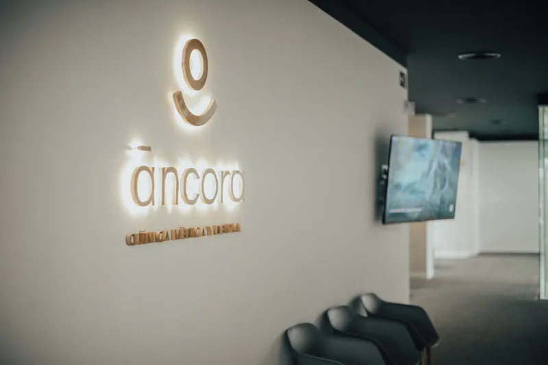 Recepción de Clínica Áncora en Málaga, con el logotipo de la clínica iluminado en la pared