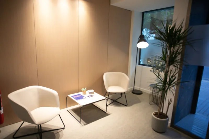 Sala de espera de Clínica Áncora, con dos butacas, una mesa baja y luz natural